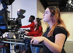 传媒专业的学生在十大玩彩信誉平台室里运行摄像机.